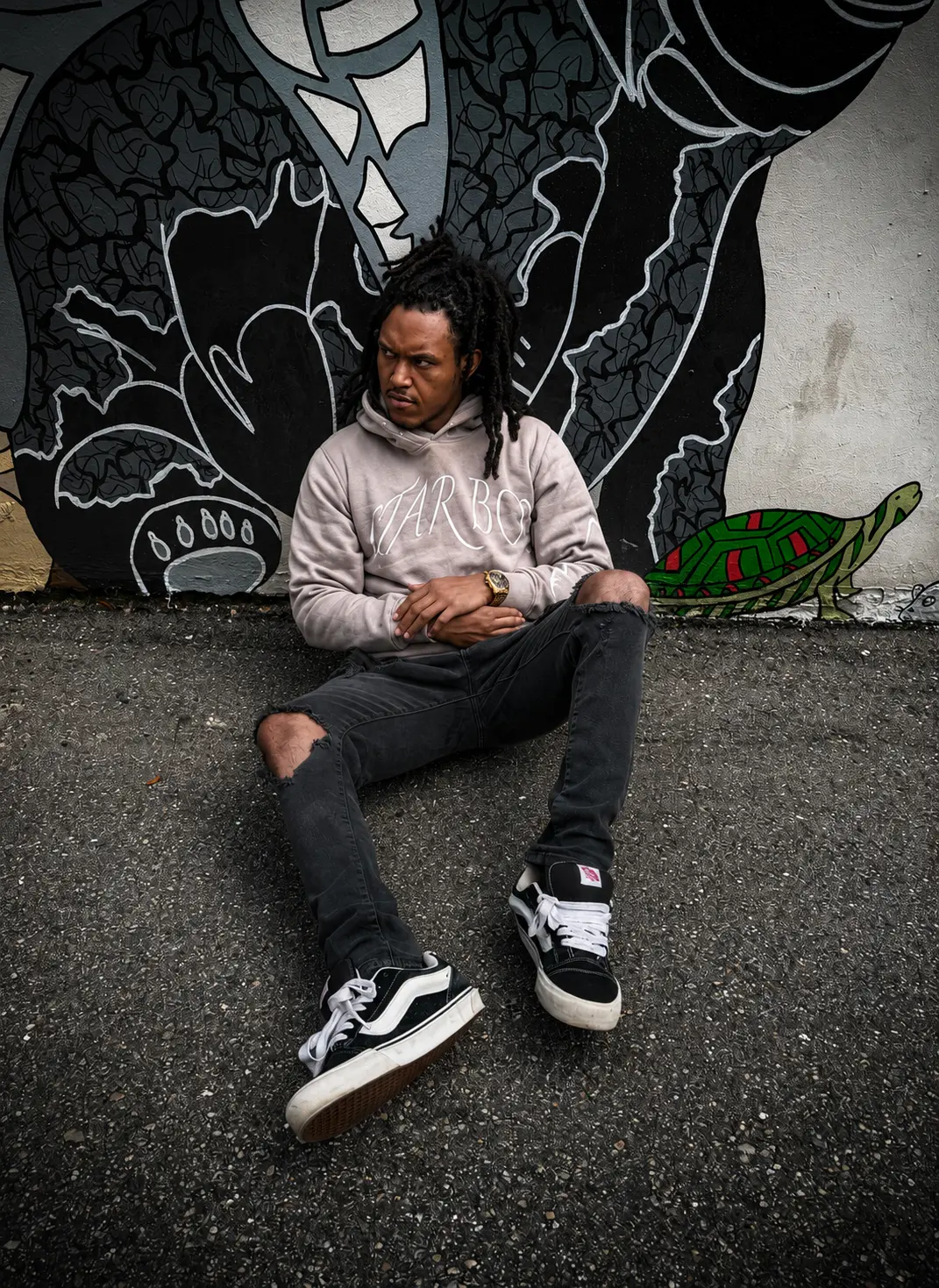 Angel Gear hoodie worn against a painted city wall